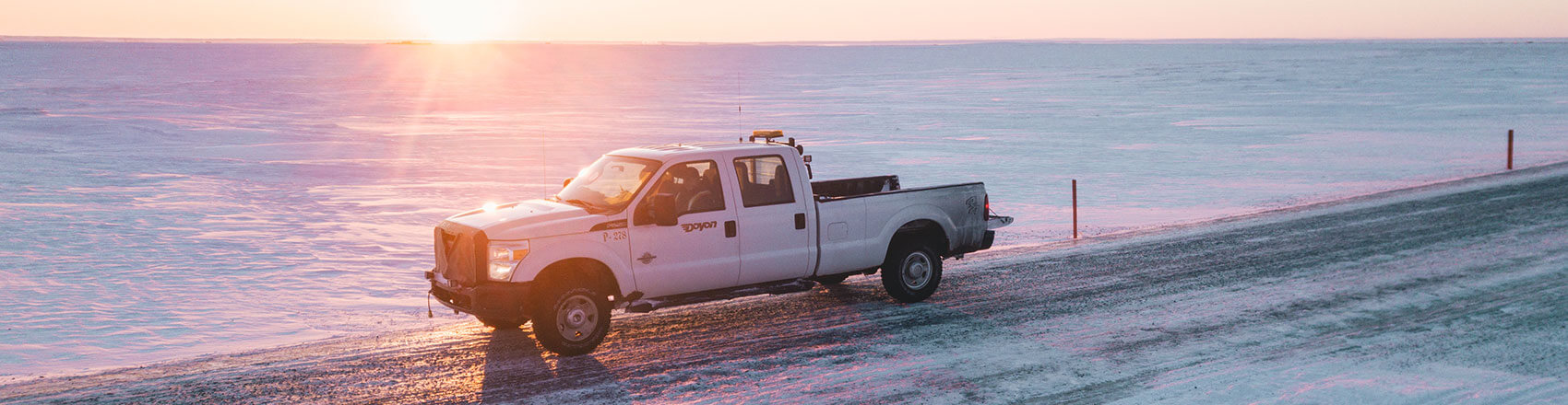 Doyon Drilling truck with sunrise in the background.