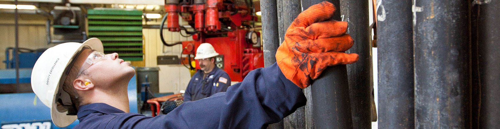 Doyon Drilling worker arranges pipes in a warehouse.